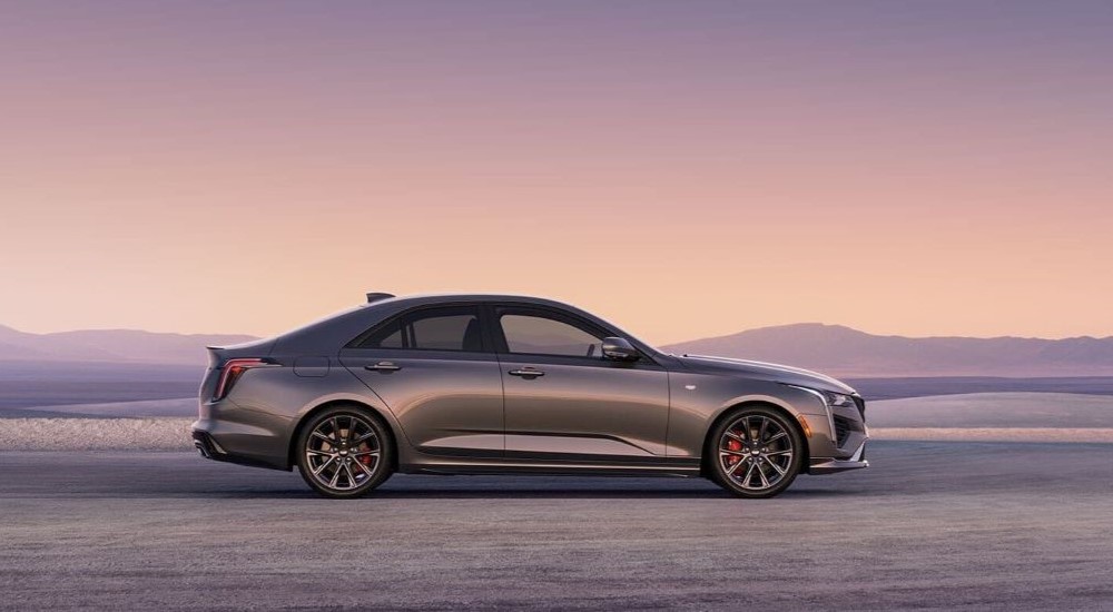 A grey 2024 Cadillac CT4 is shown from the side after leaving a New Ulm Cadillac dealer.