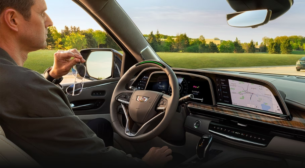 A man is using Super Cruise in a 2024 Cadillac Escalade during a test drive with a Cadillac dealer near Northfield.