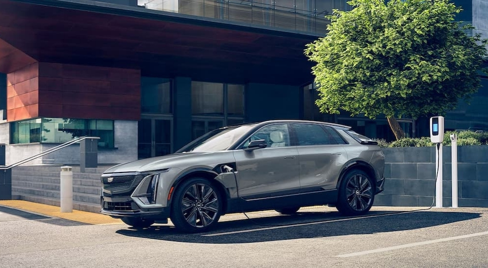 A silver 2024 Cadillac LYRIQ for sale is parked while charging.