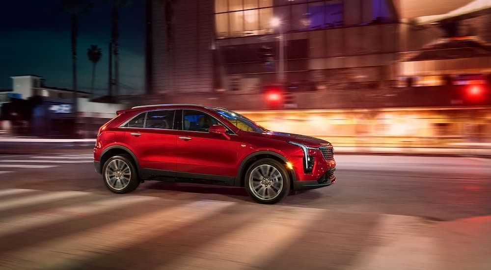 A red 2024 Cadillac XT4 for sale speeding through a city street.