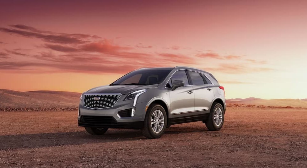 A silver 2023 Cadillac XT5 parked in an open desert near a Mankato Cadillac dealer.