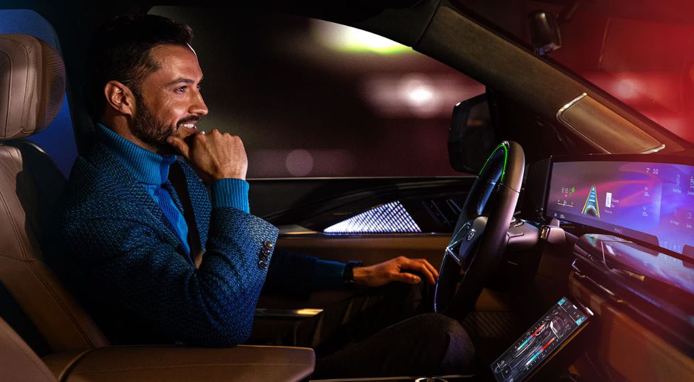 A man driving at night using the Super Cruise feature in a 2025 Cadillac Escalade.