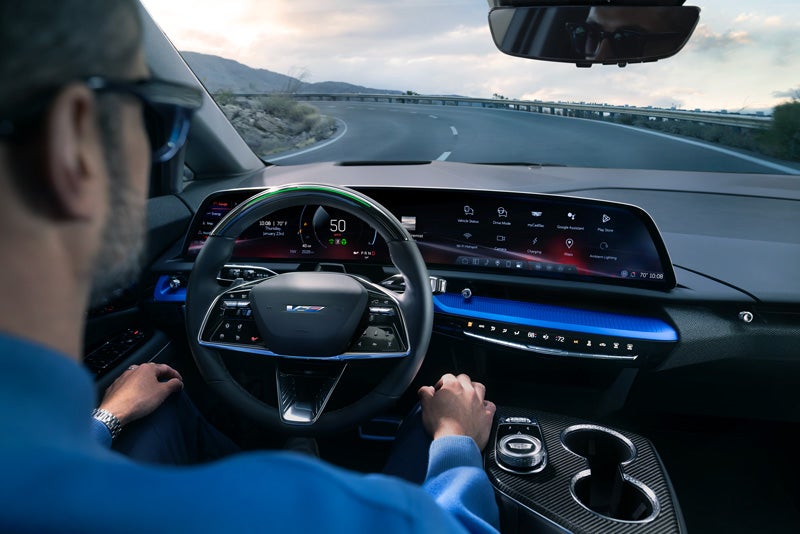 Front View of the 2026 OPTIQ-V Driving Through the Dusk Utilizing its Headlights | Snell Motors in Mankato MN