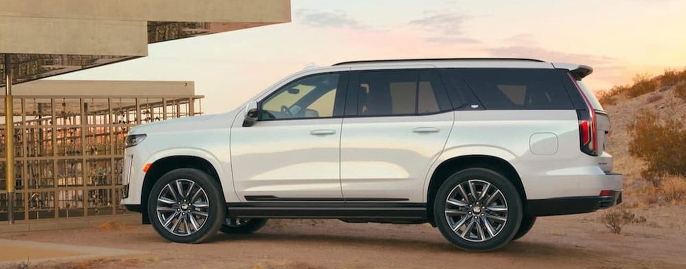 White 2021 Cadillac Escalade shown from the side, and parked near construction.