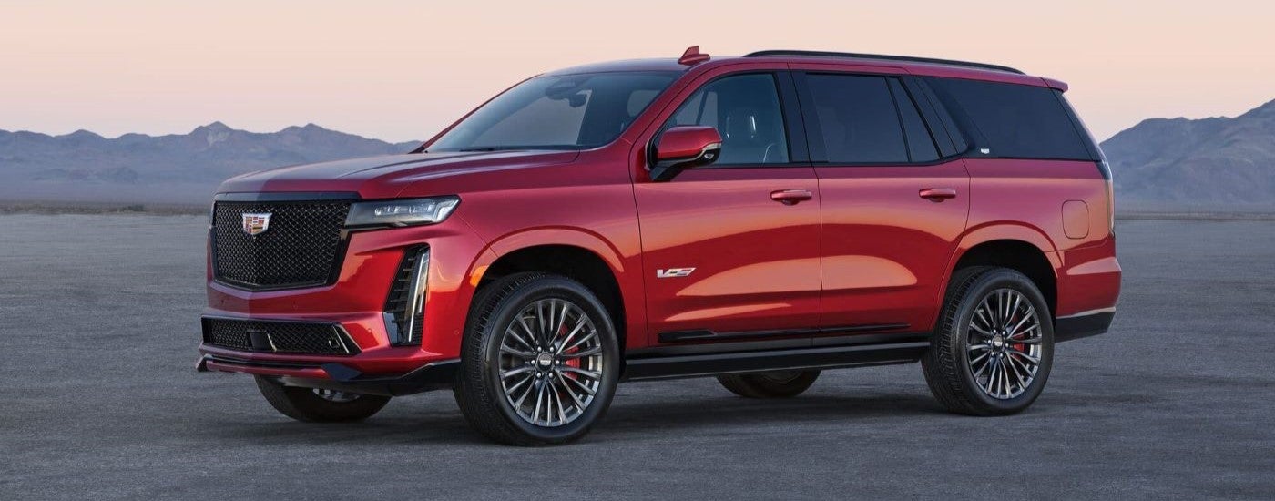 Red 2023 Cadillac Escalade V from the side in the desert.