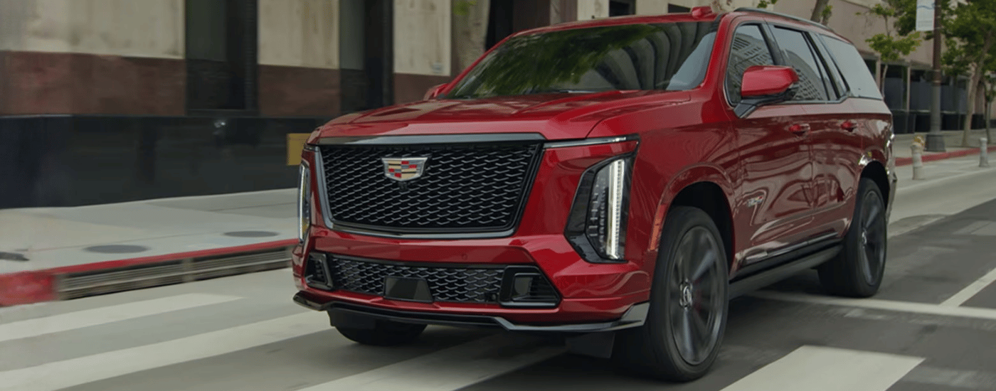 Red 2026 Cadillac Escalade driving through a crosswalk