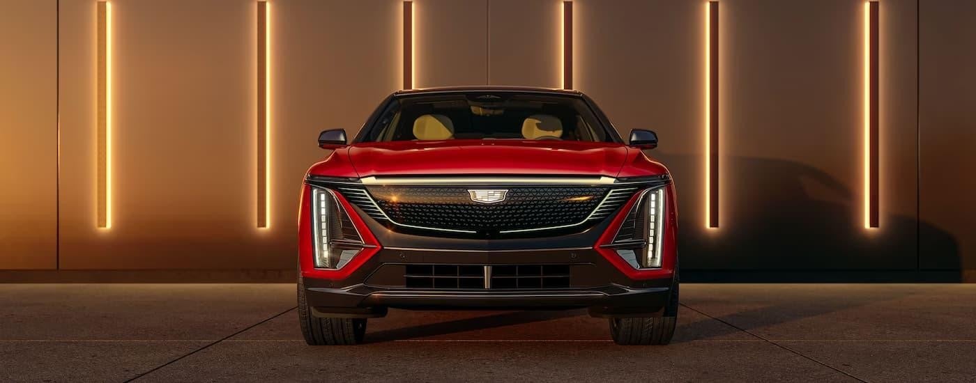 A red 2025 Cadillac LYRIQ is parked outside of a Cadillac dealer near Northfield.