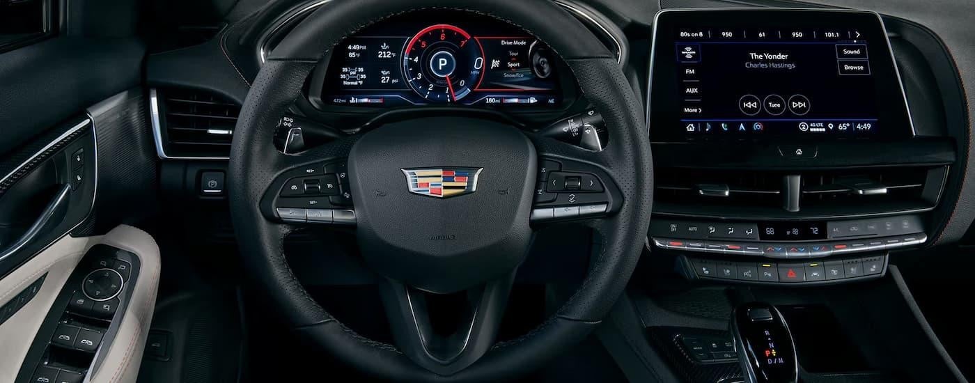 A close up of the black steering wheel and dashboard of a 2024 Cadillac CT5.