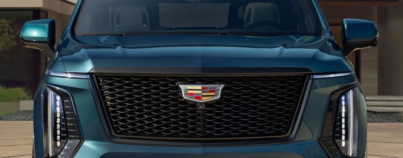 A close up of the front grille on a blue 2025 Cadillac Escalade.