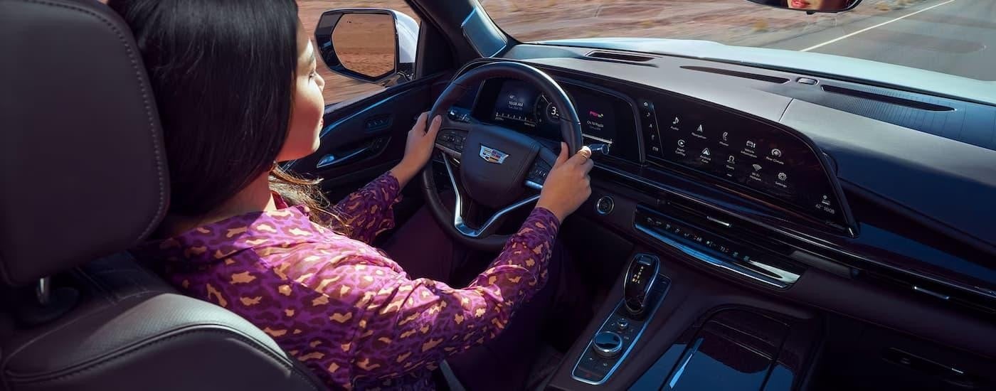 A woman is shown driving a 2023 Cadillac Escalade to a Cadillac dealer in Mantako.