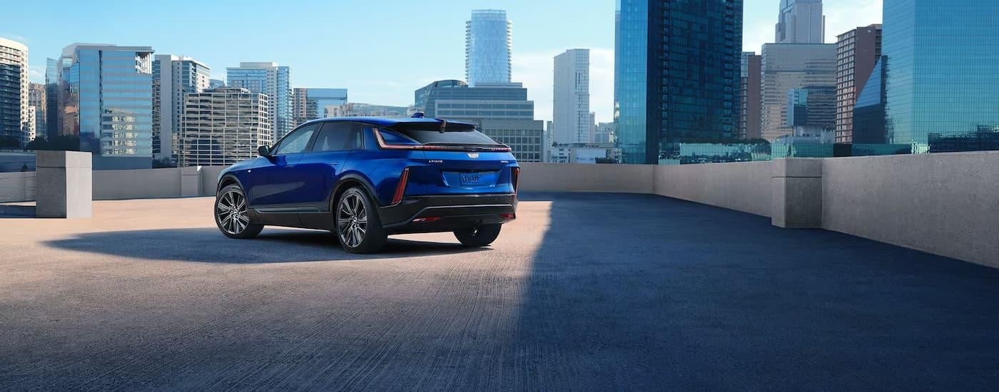 A rear view of a blue 2025 Cadillac LYRIQ parked on a rooftop garage.