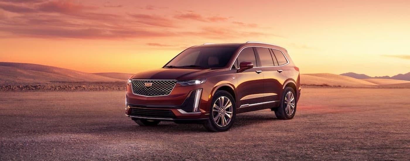 A red 2024 Cadillac XT6 is shown from the front at an angle.