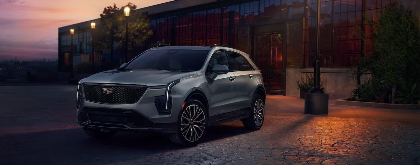 A silver 2024 Cadillac XT4 is shown parked on a city street.