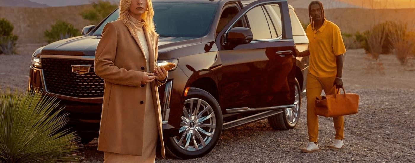 A couple is shown standing next to a brown 2023 Cadillac Escalade after leaving a New Ulm Cadillac dealer.