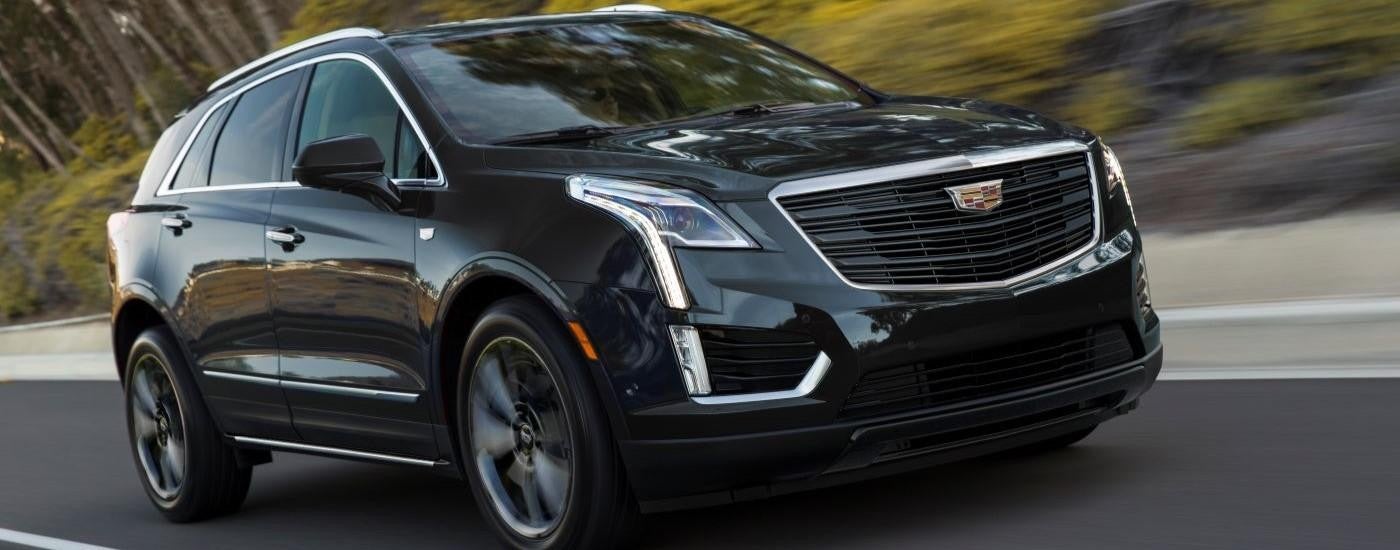 A black 2019 Cadillac XT5 Sport is shown speeding on an open highway.