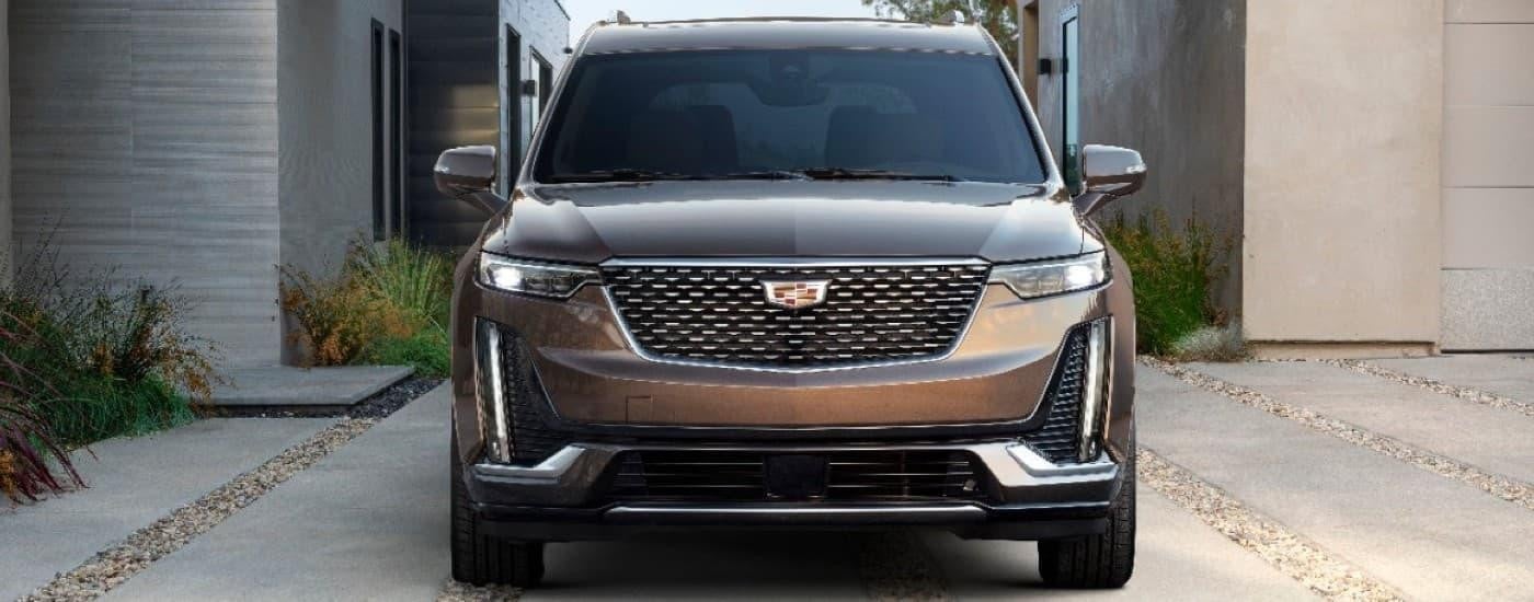 A brown 2020 Cadillac XT6 is shown parked in a driveway is shown after leaving a used Cadillac dealer.
